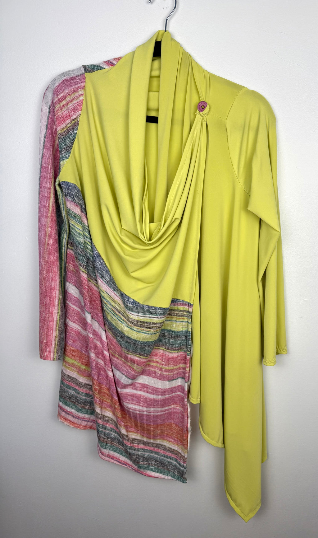 Handmade lime green draped cardigan with asymmetrical colourblock striped panel in pink and green tones on hanger