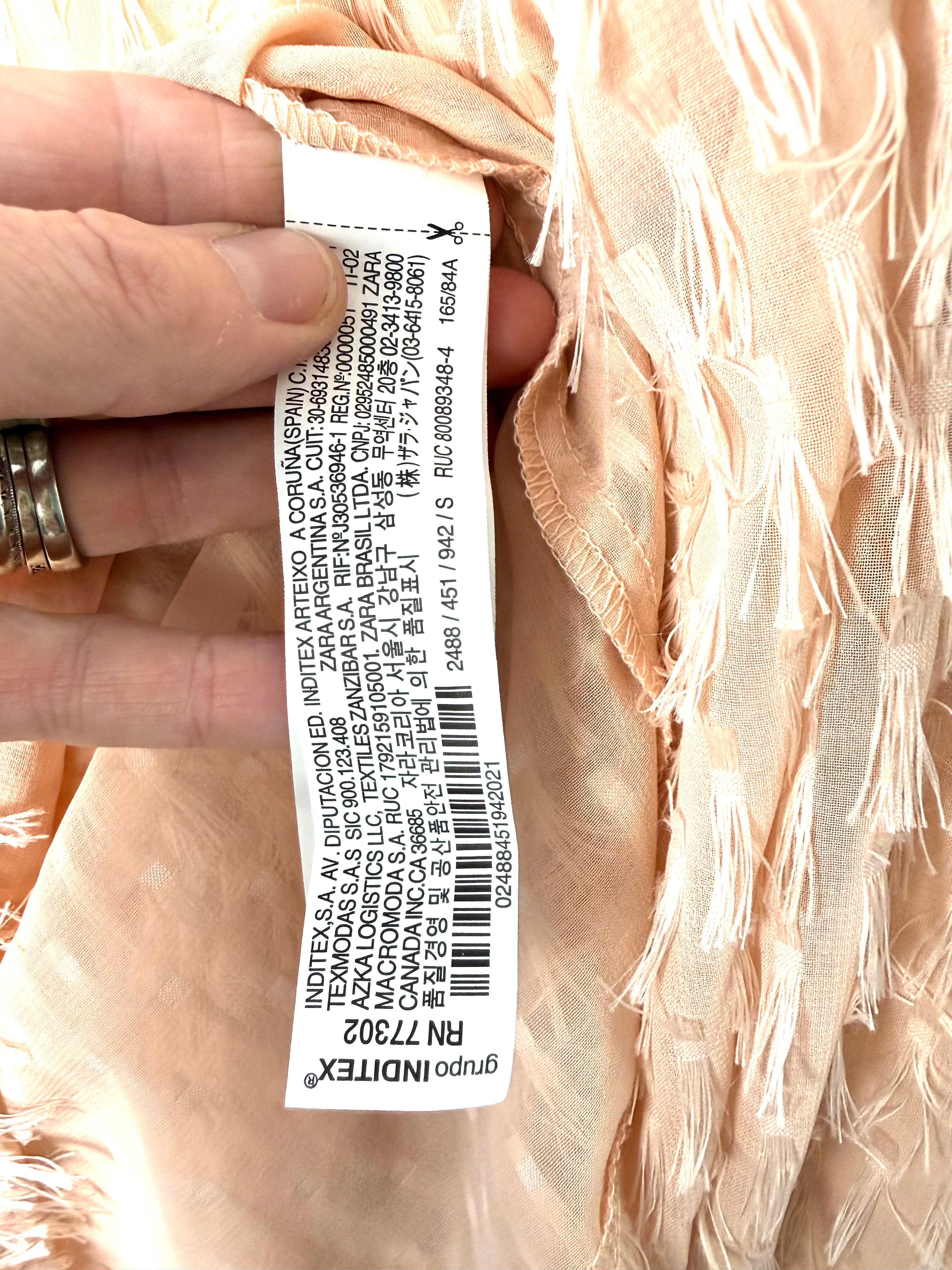 Hang tag inside feathery Zara blush coloured top in modern boho style 