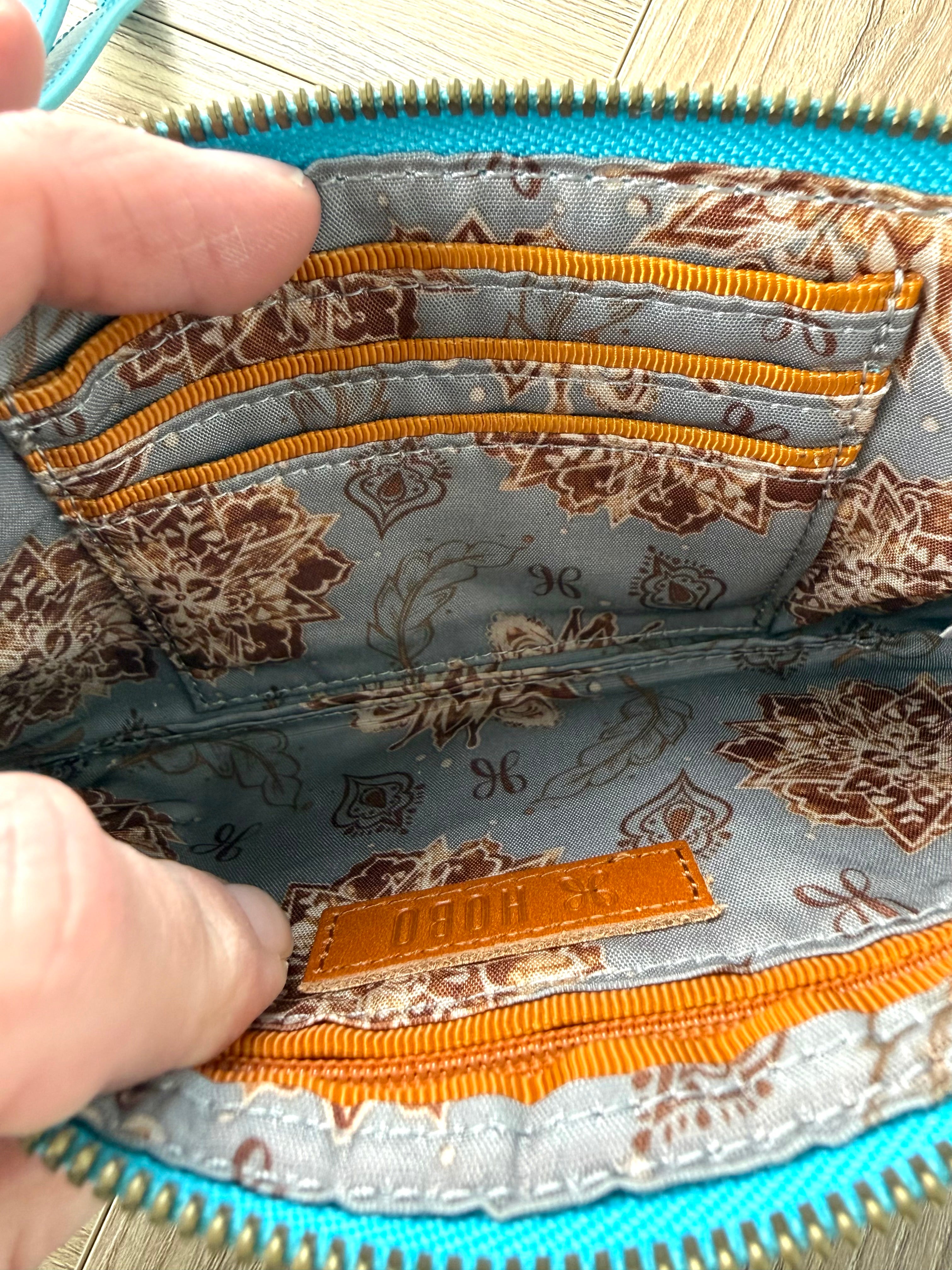 HOBO Evolve wristlet interior with multiple card slots, zip pocket, and patterned lining.