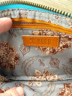 Interior of HOBO Evolve leather wristlet with floral fabric lining, HOBO leather logo patch, and zipper pocket.