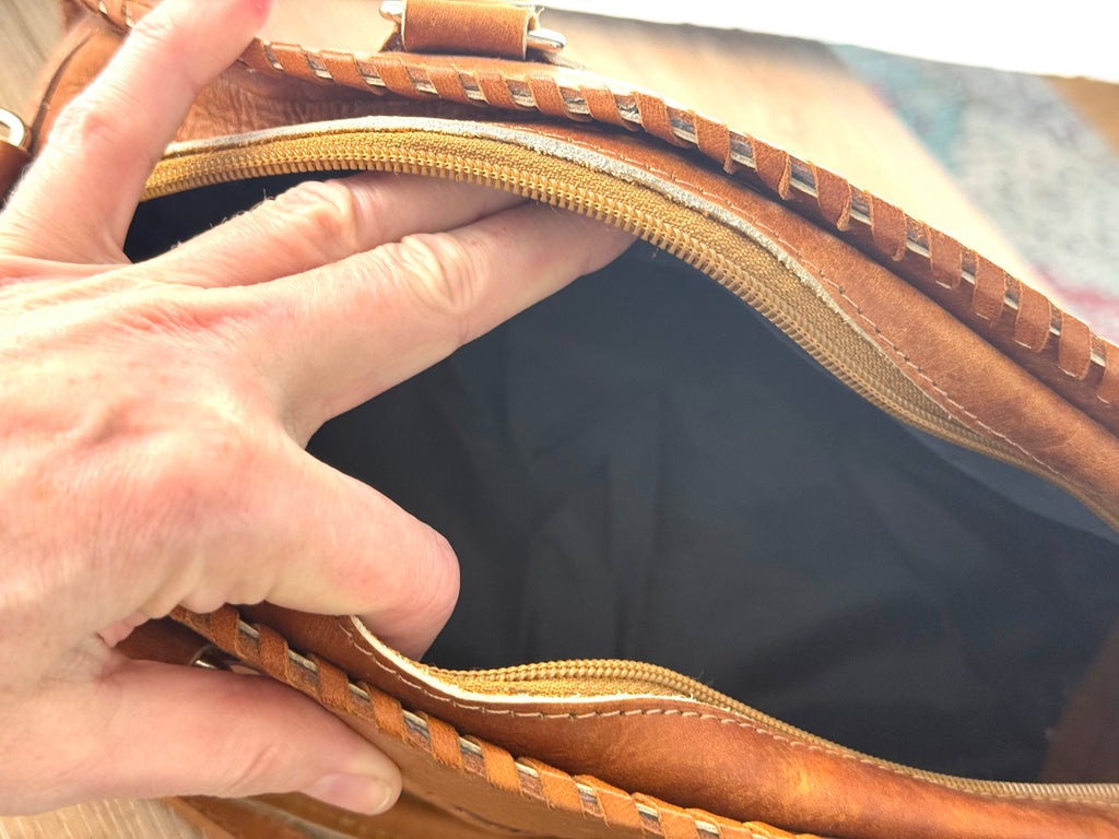 Interior of vintage leather handbag showing clean lining and zip closure