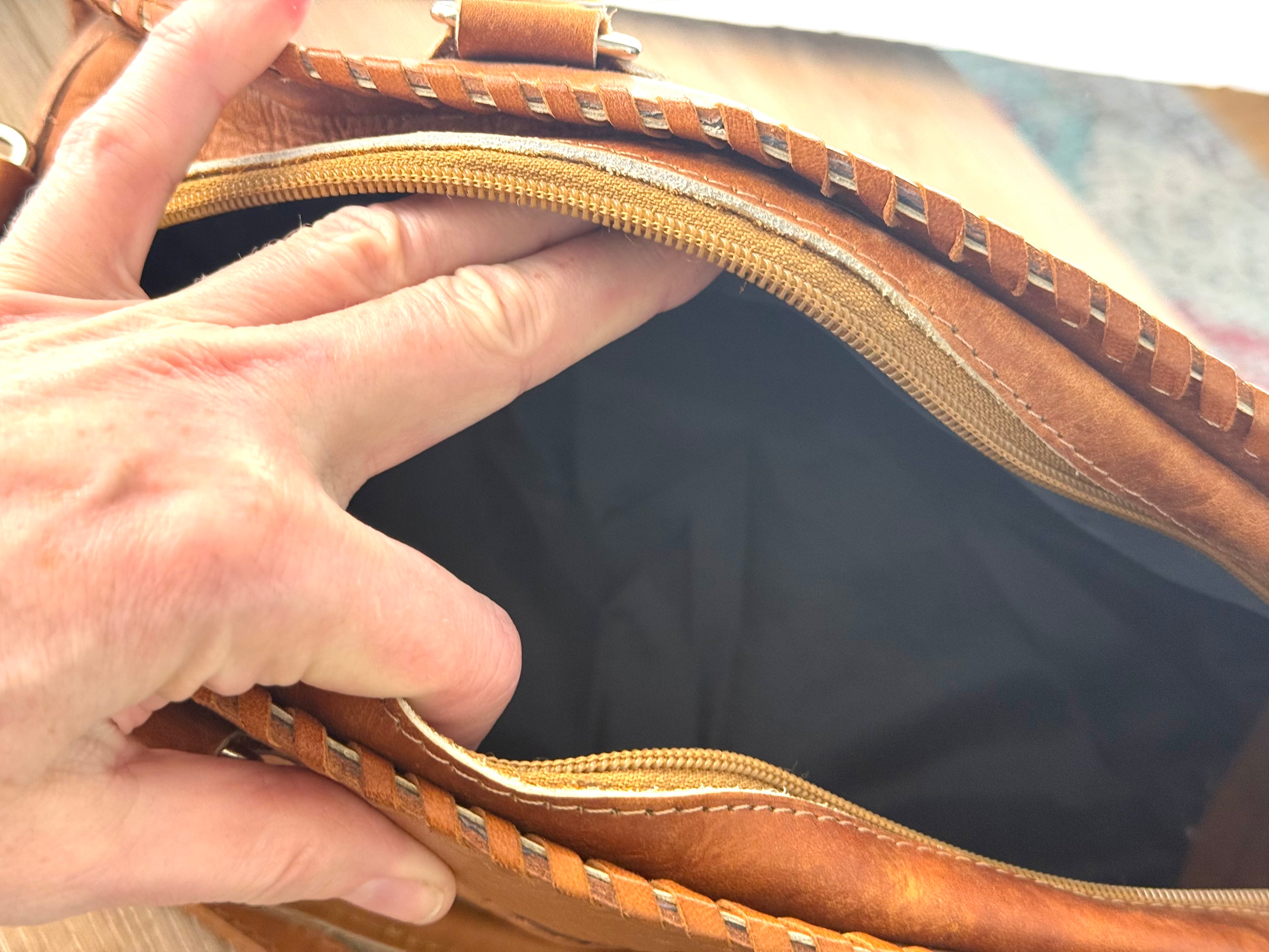 Interior of vintage leather handbag showing clean lining and zip closure