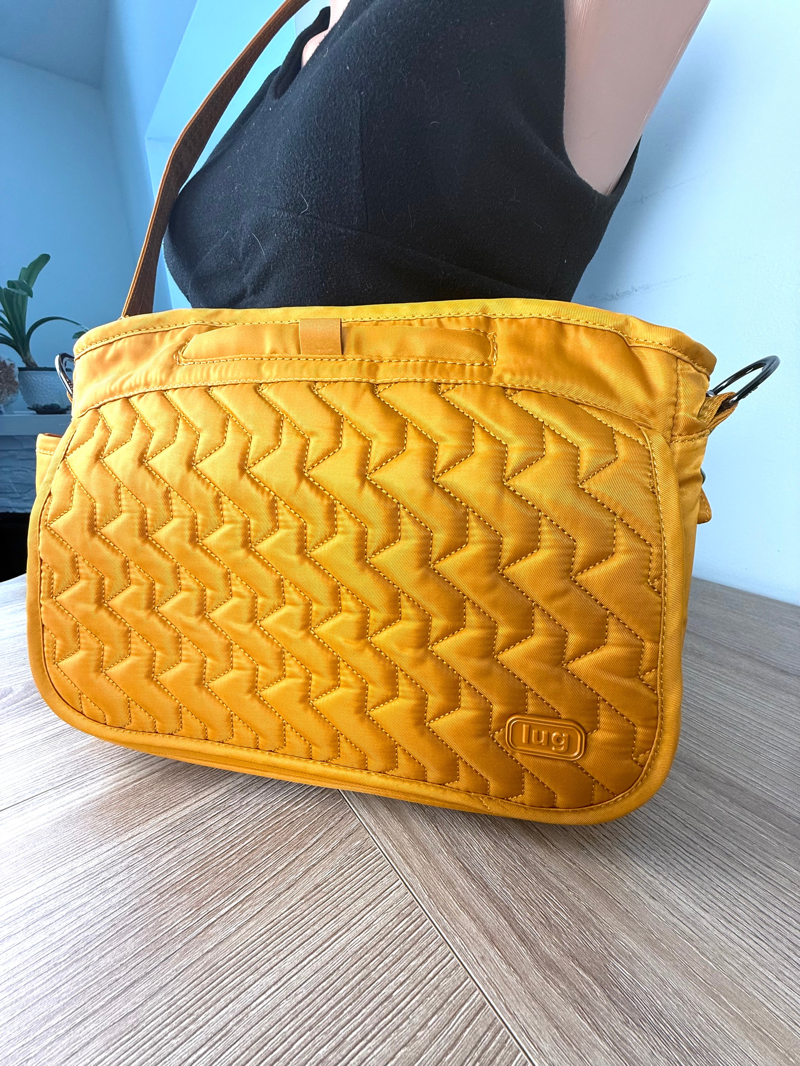 Lug crossbody travel bag in mustard yellow on mannequin side view