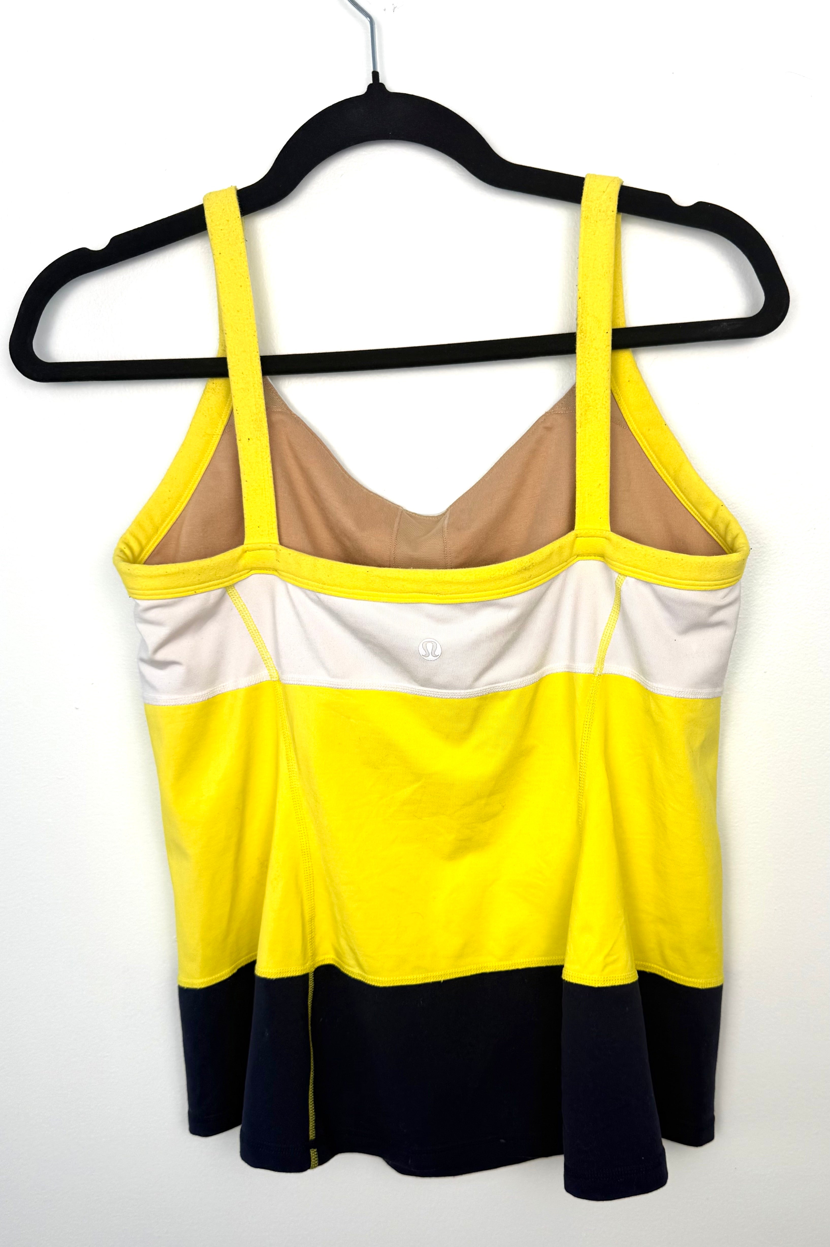 Back view of Lululemon athletic tank top with wide yellow straps, built-in bra lining, and colour block design in white, yellow, and black.