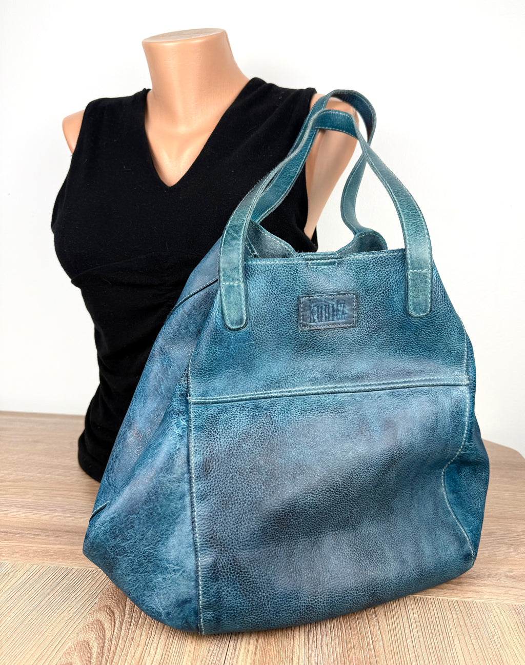 Made in Canada  Kunitz handcrafted leather tote bag beside mannequin to show scale 