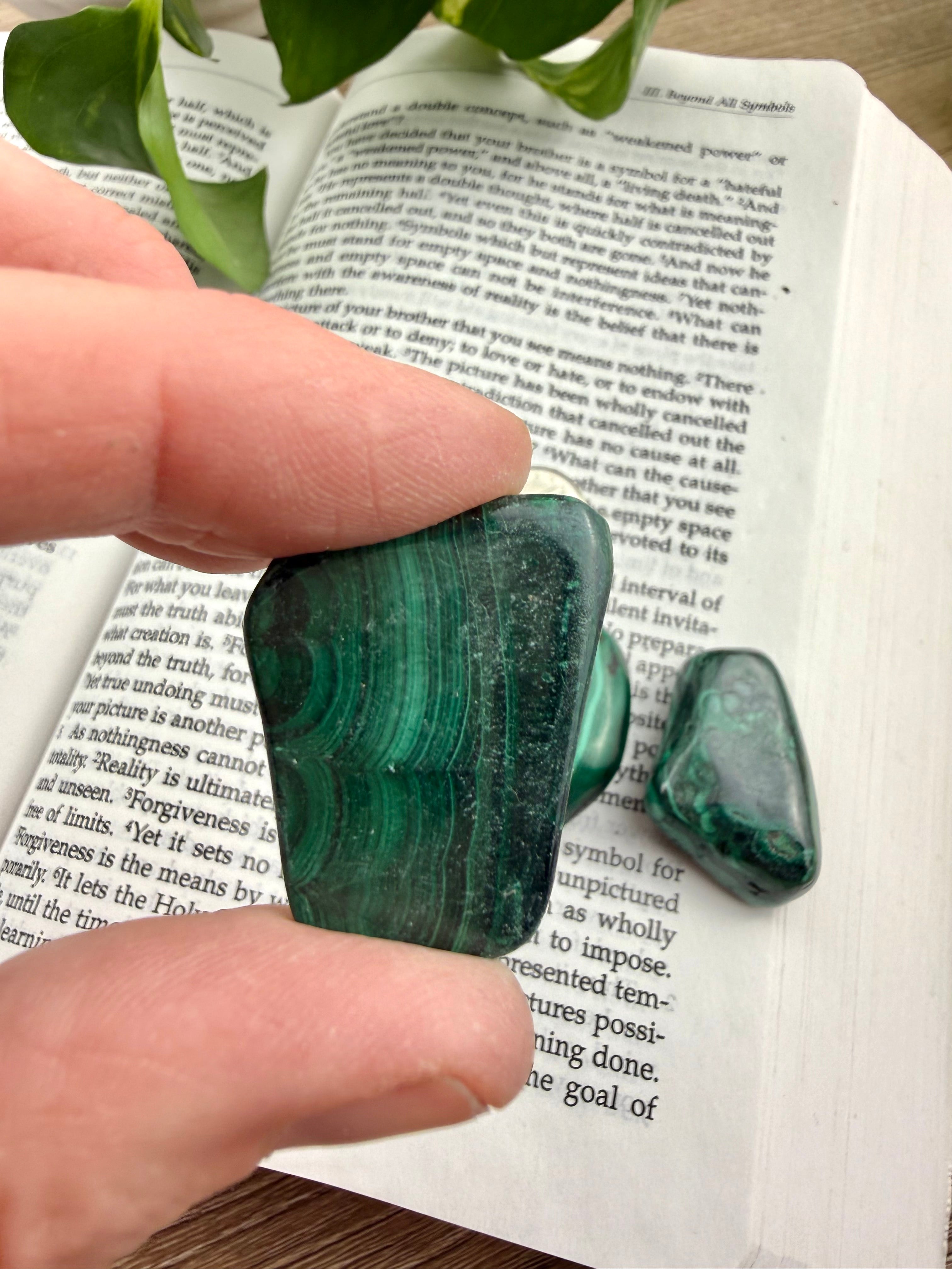 Green malachite stone held over an open book