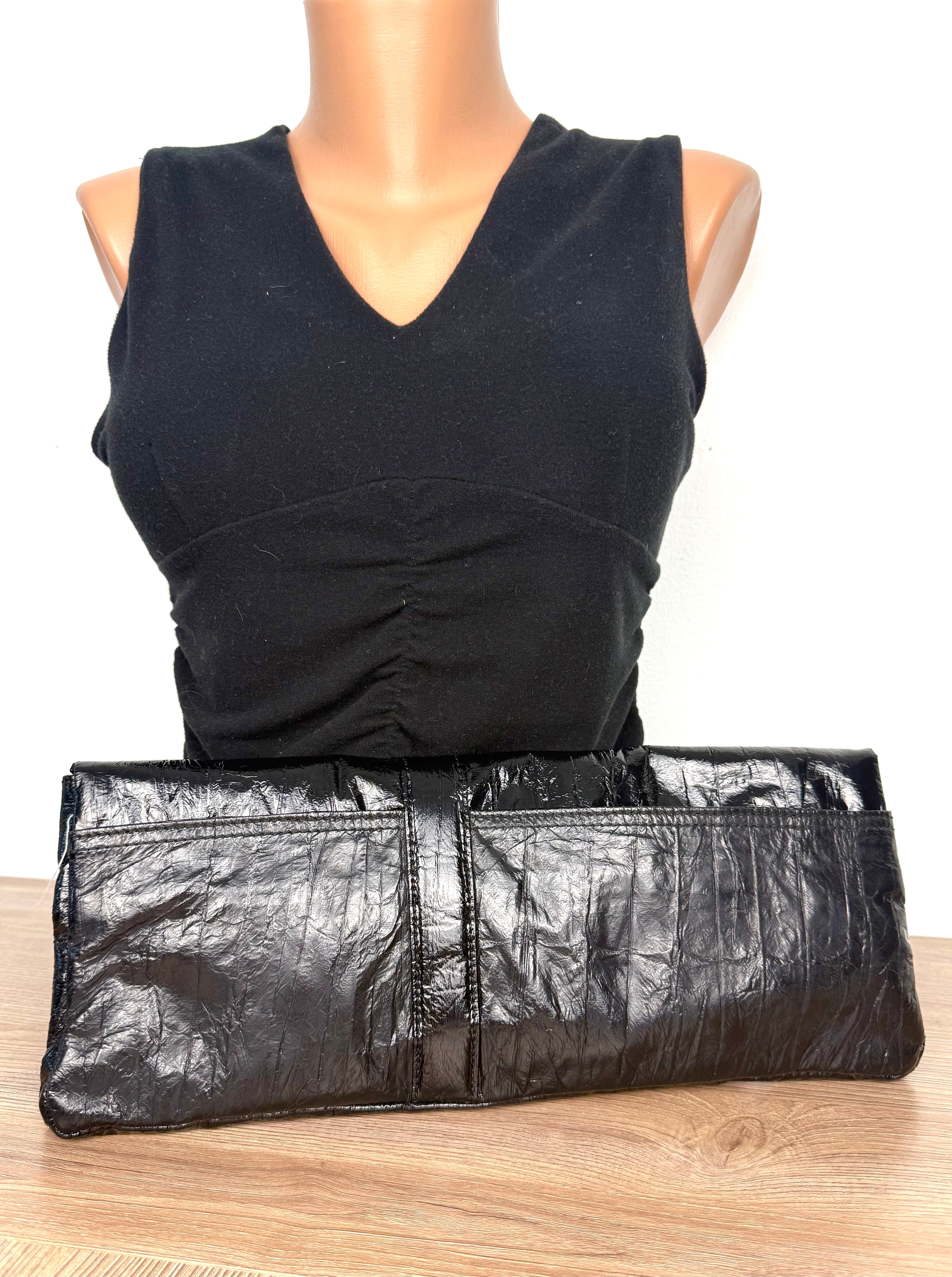 back of Matt & Nat Black Vegan Leather Clutch Bag on mannequin to show scale 