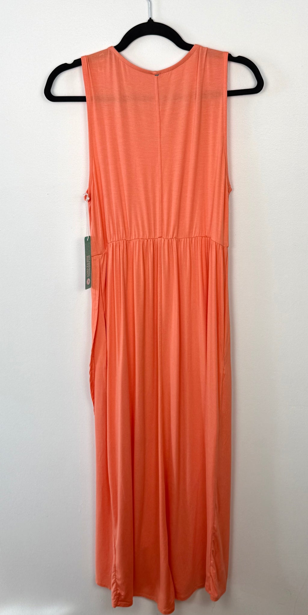 back view of sweet legs coral coloured sleeveless dress on a hanger against a white background