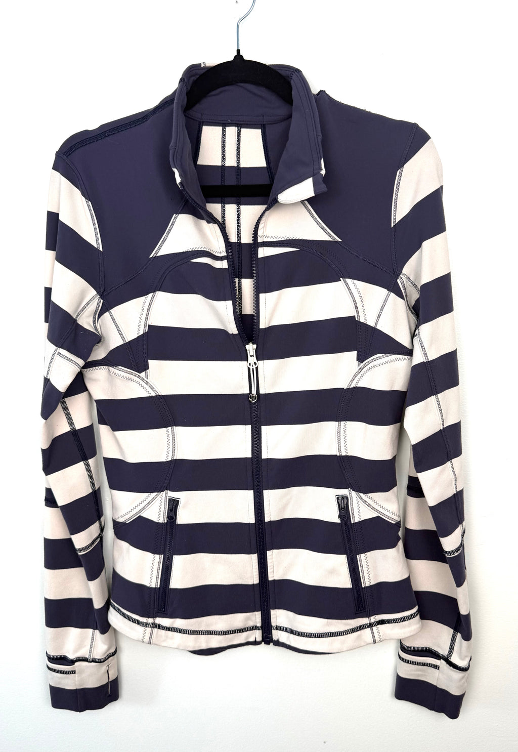 navy and cream striped Lululemon sweater with high collar and zip pockets.