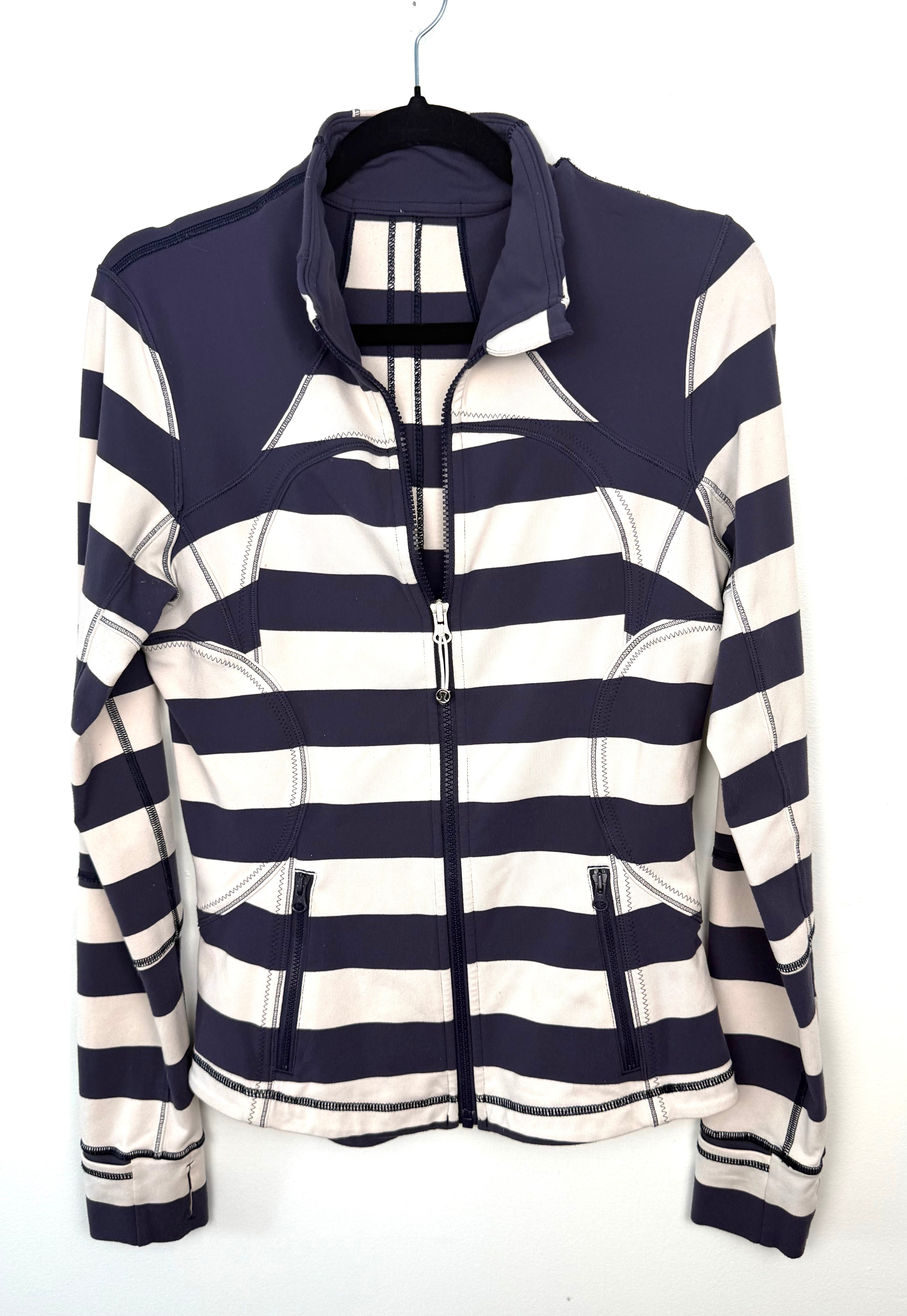 navy and cream striped Lululemon sweater with high collar and zip pockets.