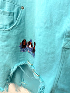 Oversized Turquoise denim romper close up of hem with fun detail and decals