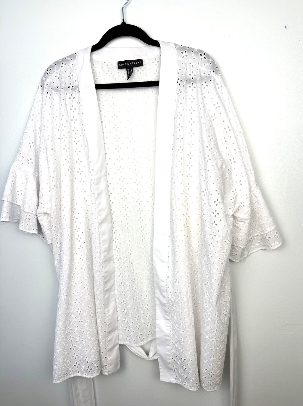 Oversized open front boho layering piece with floral eyelet embroidery and ruffle sleeves.