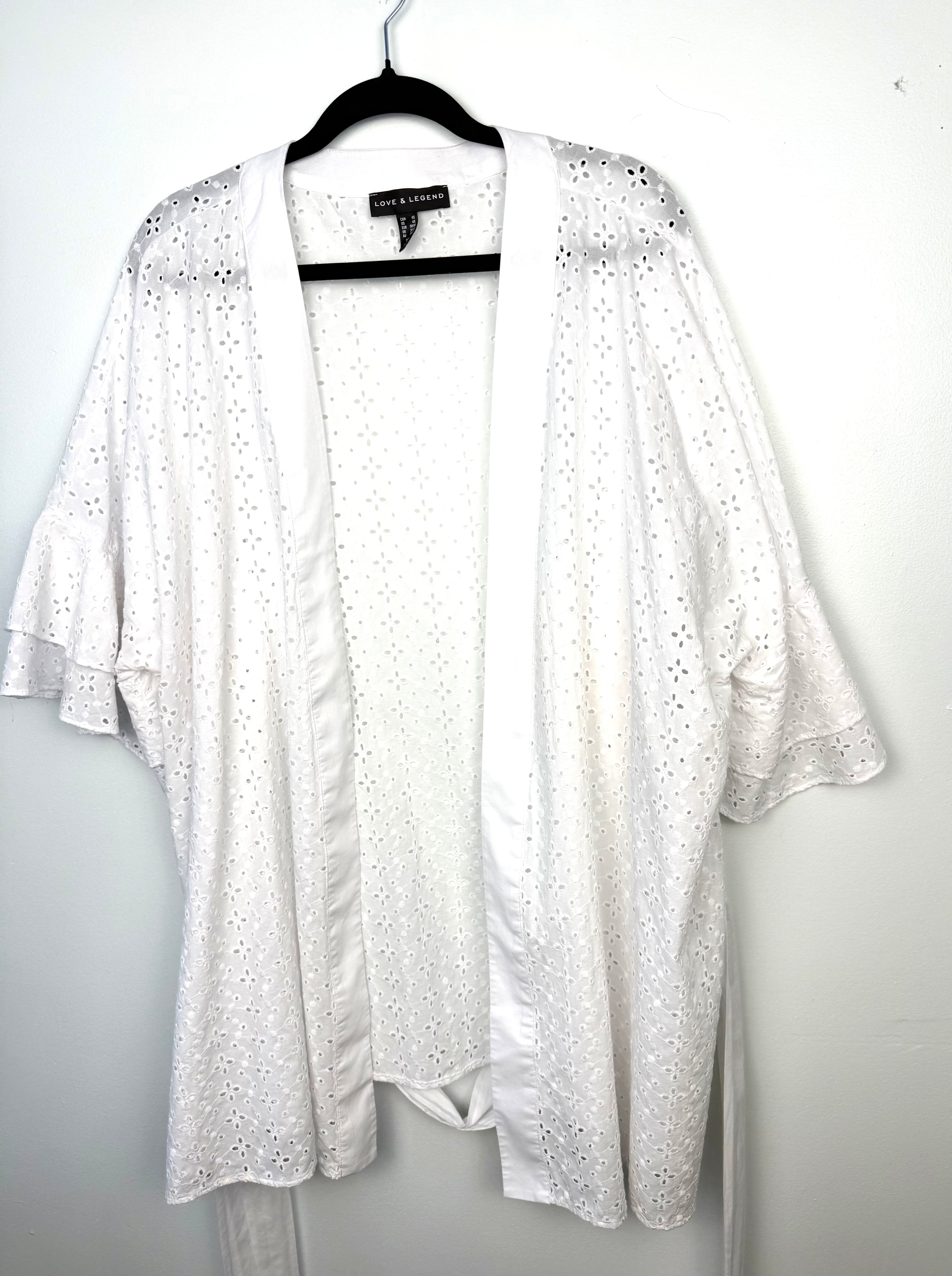 Oversized open front boho layering piece with floral eyelet embroidery and ruffle sleeves.
