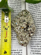 Pyrite with measuring tape showing it to be approx 4 inches long 