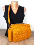 Retired Lug Wings Travel Cross Body Bag in mustard yellow. on mannequin for size