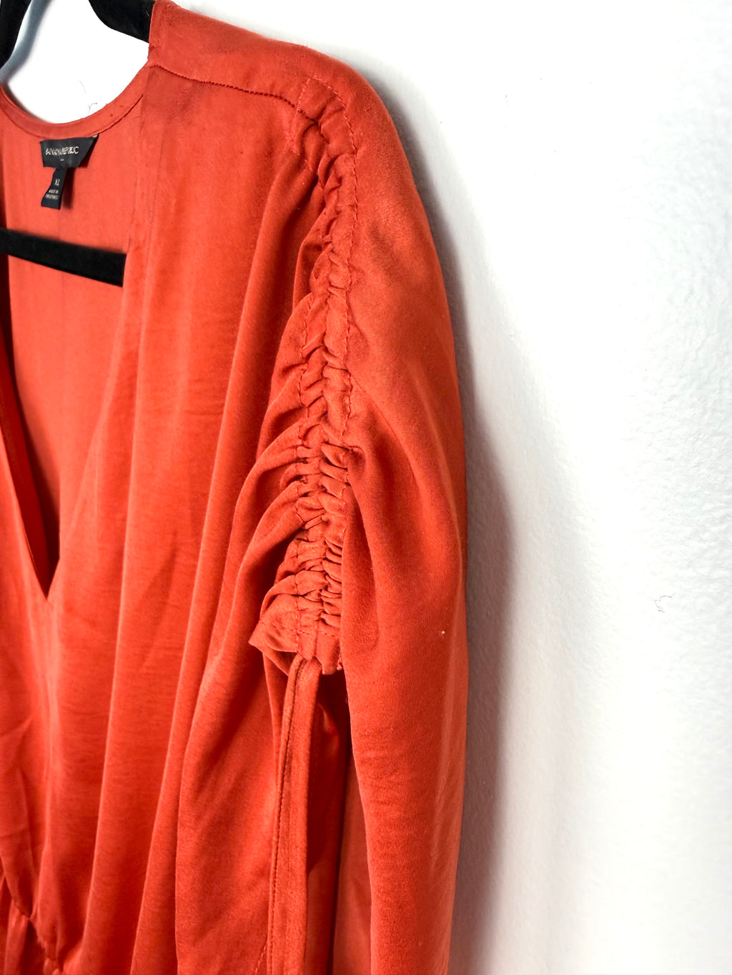 Ruched sleeve detail on back of Banana Republic peplum top in rust 