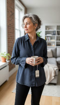 Sandwich Denim Studio Amsterdam charcoal 100% Tencel shirt with stunning hand-applied blue crystal collar embellishment and ruffle cuff detail at Blue Sparrow Shop on woman drinking tea