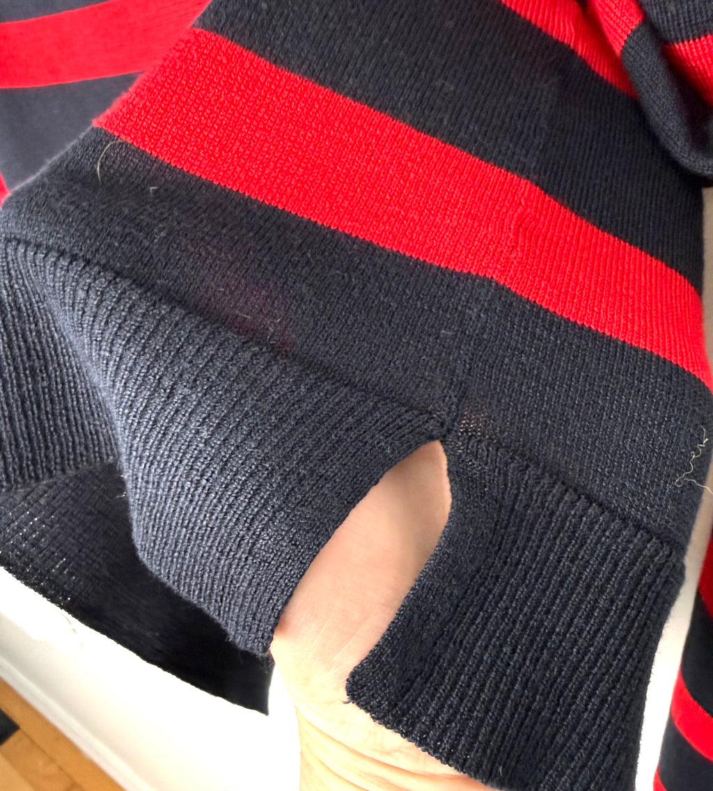 side slit at hem of Zara brand nautical striped sweater in navy and red - hand holding it to show 