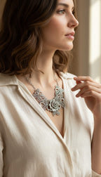 Silver-tone filigree rose bib necklace at Blue Sparrow Shop on woman looking out window 