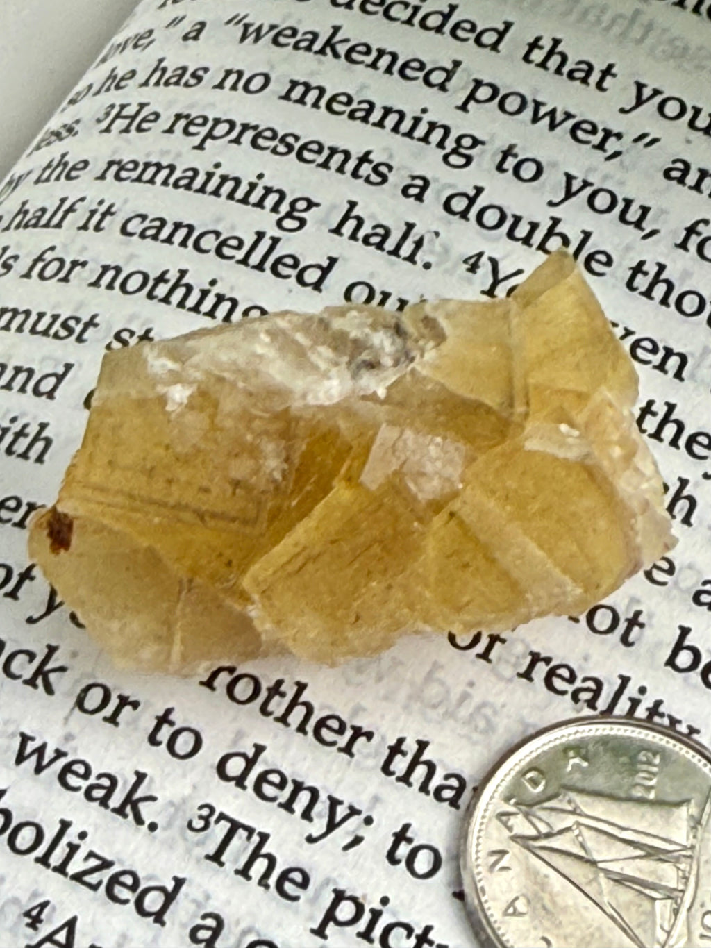 small yellow fluorite cluster on book 
