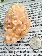 Stilbite crystal rock on a piece of paper with text