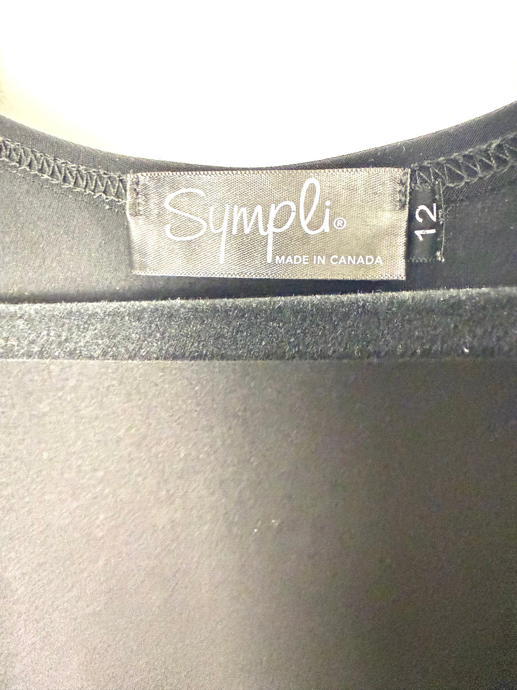 Tag on Back view Sympli black sleeveless tunic with inside pocket and stretch fabric