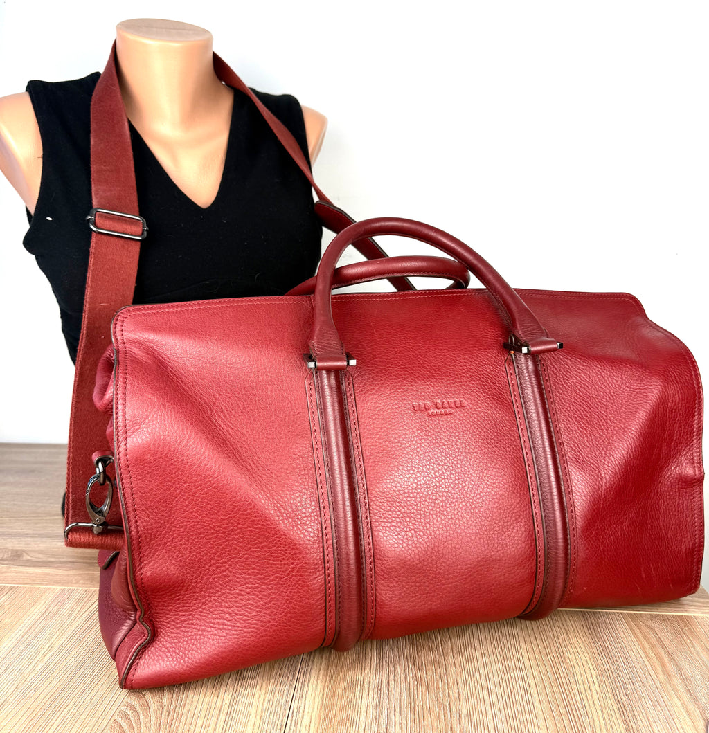 Ted Baker London red pebbled leather weekender duffel bag with adjustable shoulder strap displayed on mannequin.