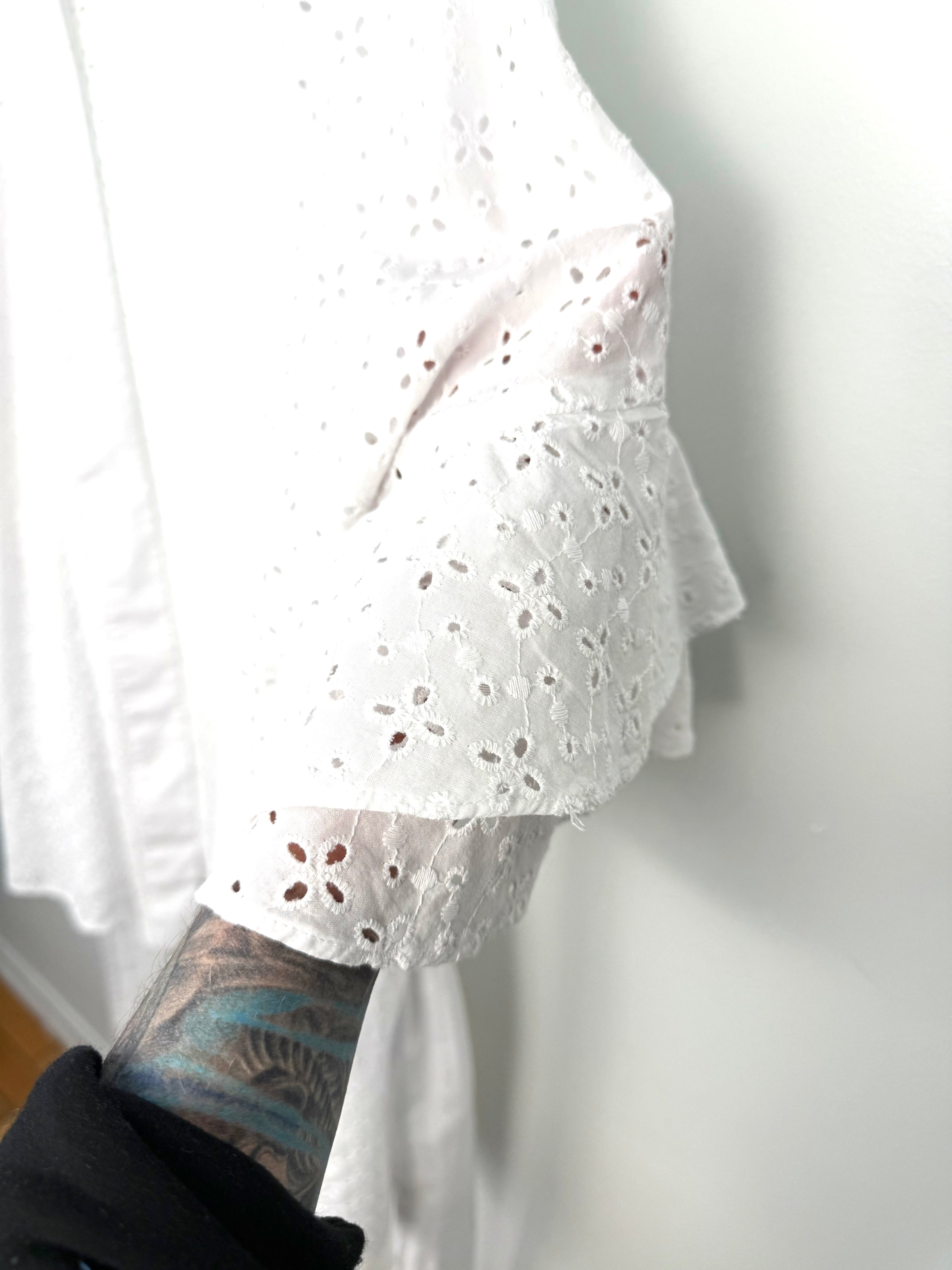Tiered ruffle sleeve detail on white eyelet kimono, feminine boho sleeve with scalloped embroidery.
