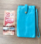 Top view turquoise HOBO wristlet clutch beside Canadian $50 bill to show size and dimensions.