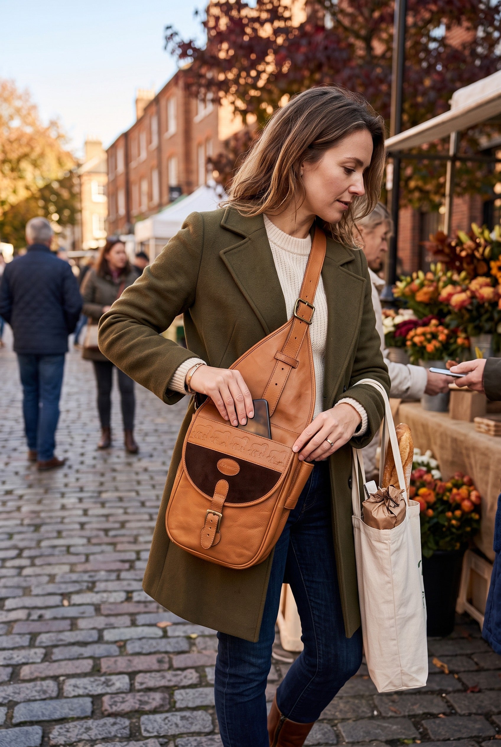 Vintage Mesace 1910 Cognac Leather Western Saddle Sling Bag on woman at outdoor market in fall 