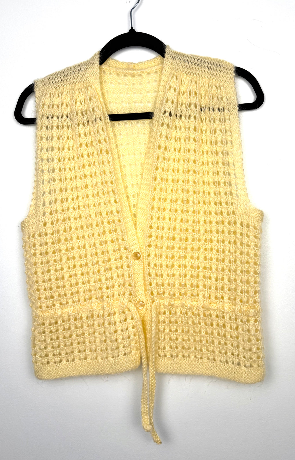 Vintage style handknit vest in yellow  on hanger