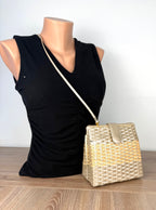 Vintage woven basket crossbody bag styled on mannequin with slim shoulder strap