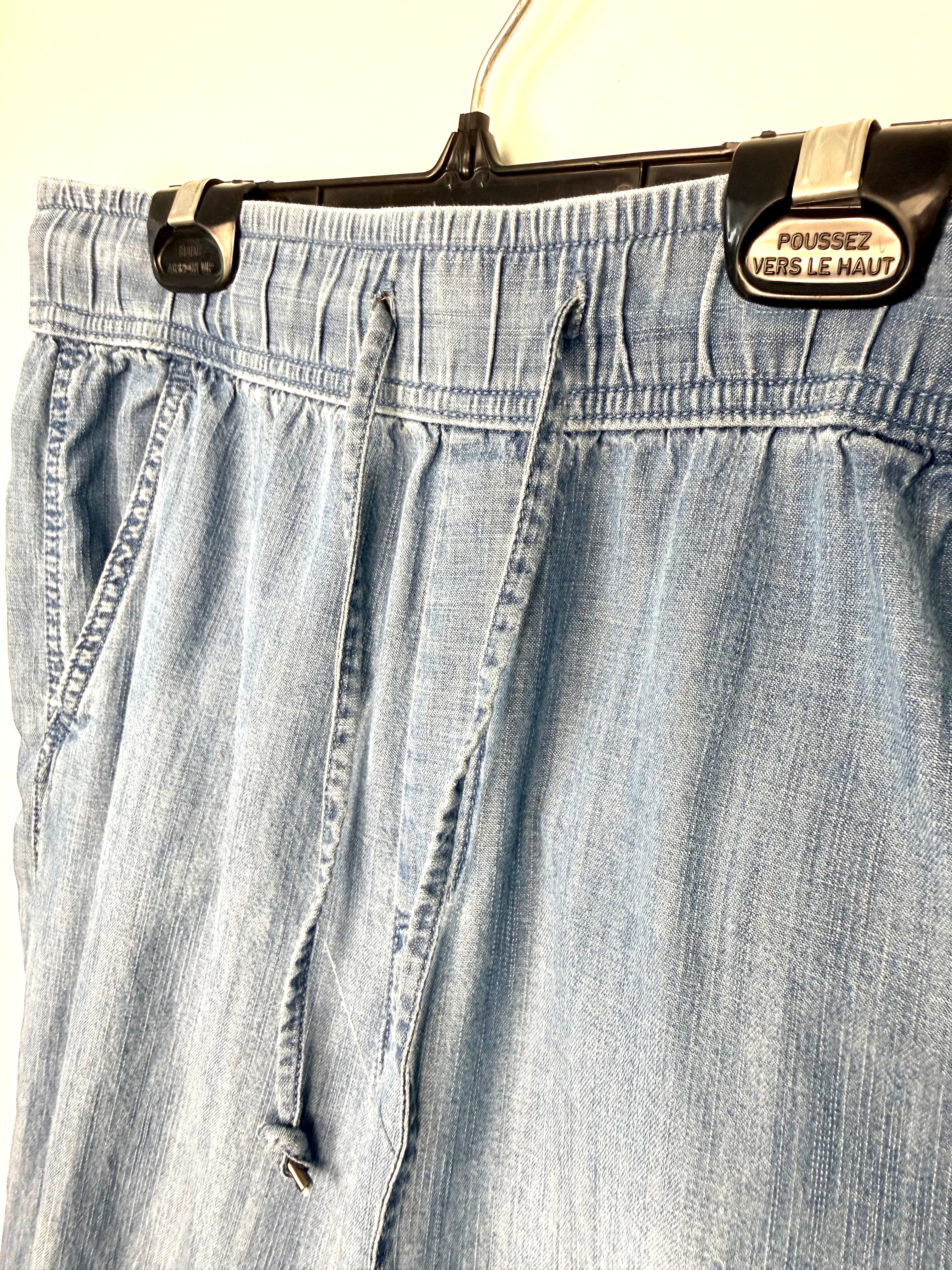 Waistband detail on Gap chambray denim joggers with elastic waist and cuff on hanger