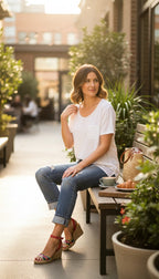 White linen blend basic, boxy, short sleeve tee with chest pocket at Blue Sparrow Shop on woman sitting on bench oustide