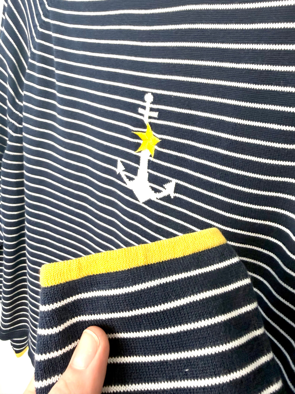 Yellow cuff trim detail on navy striped women’s pullover sweater.