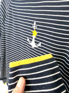 Yellow cuff trim detail on navy striped women’s pullover sweater.
