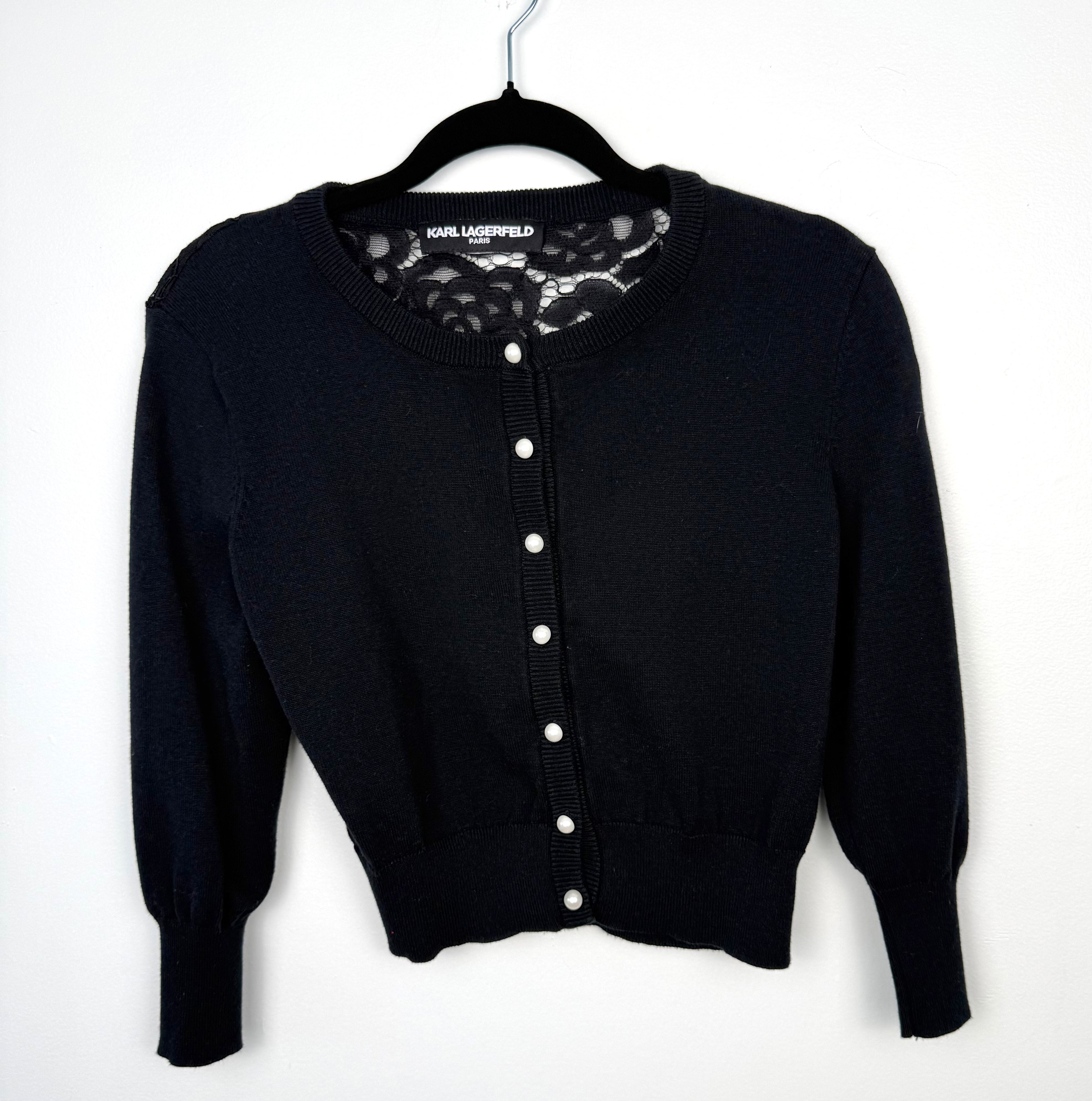 audrey hepburn style cardigan with pearl buttons and lace back detail  on hanger
