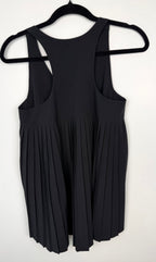 back of Athleta Black Pleated Flowy Tank Top at Blue Sparrow Shop on woman looking out patio door