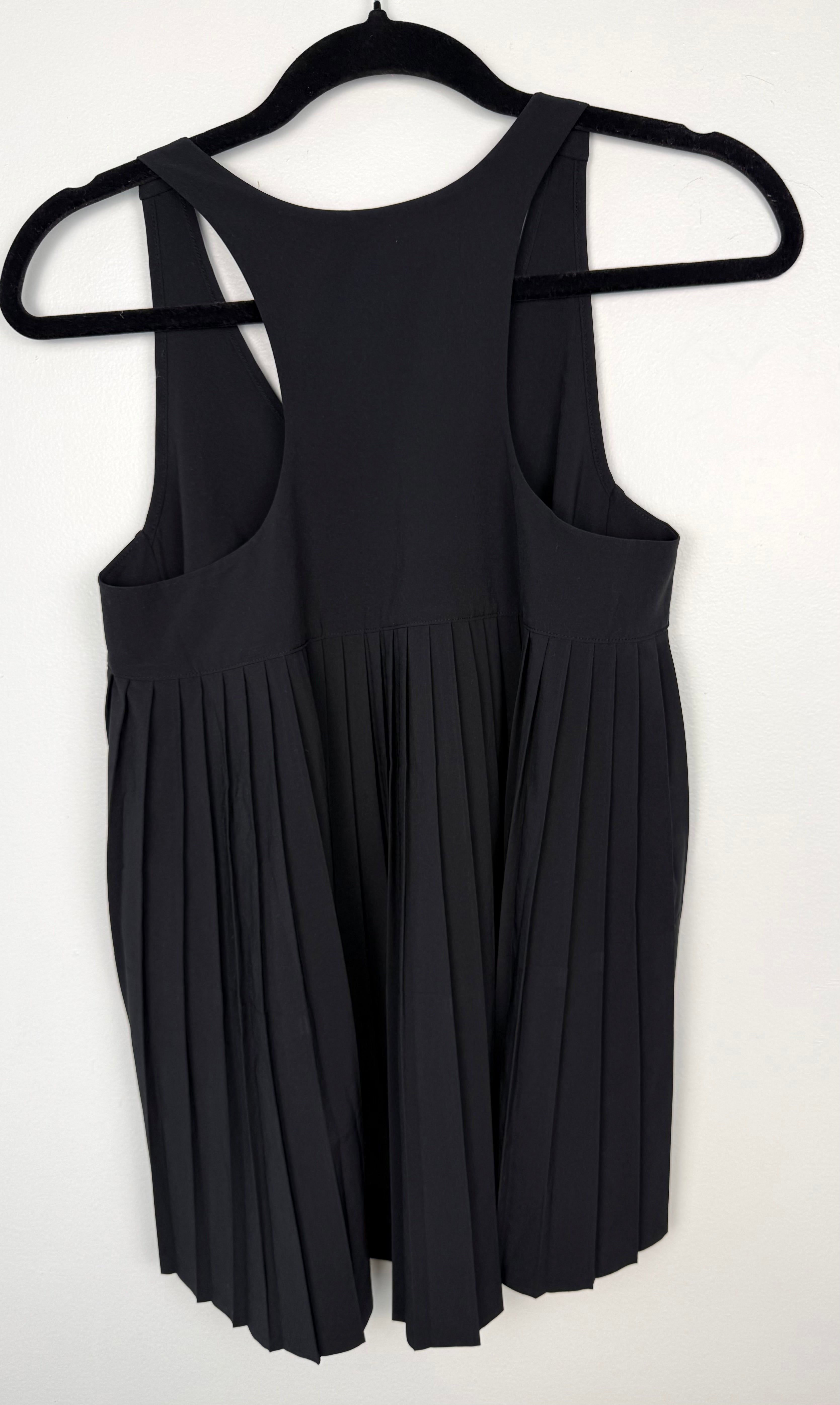 back of Athleta Black Pleated Flowy Tank Top at Blue Sparrow Shop on woman looking out patio door