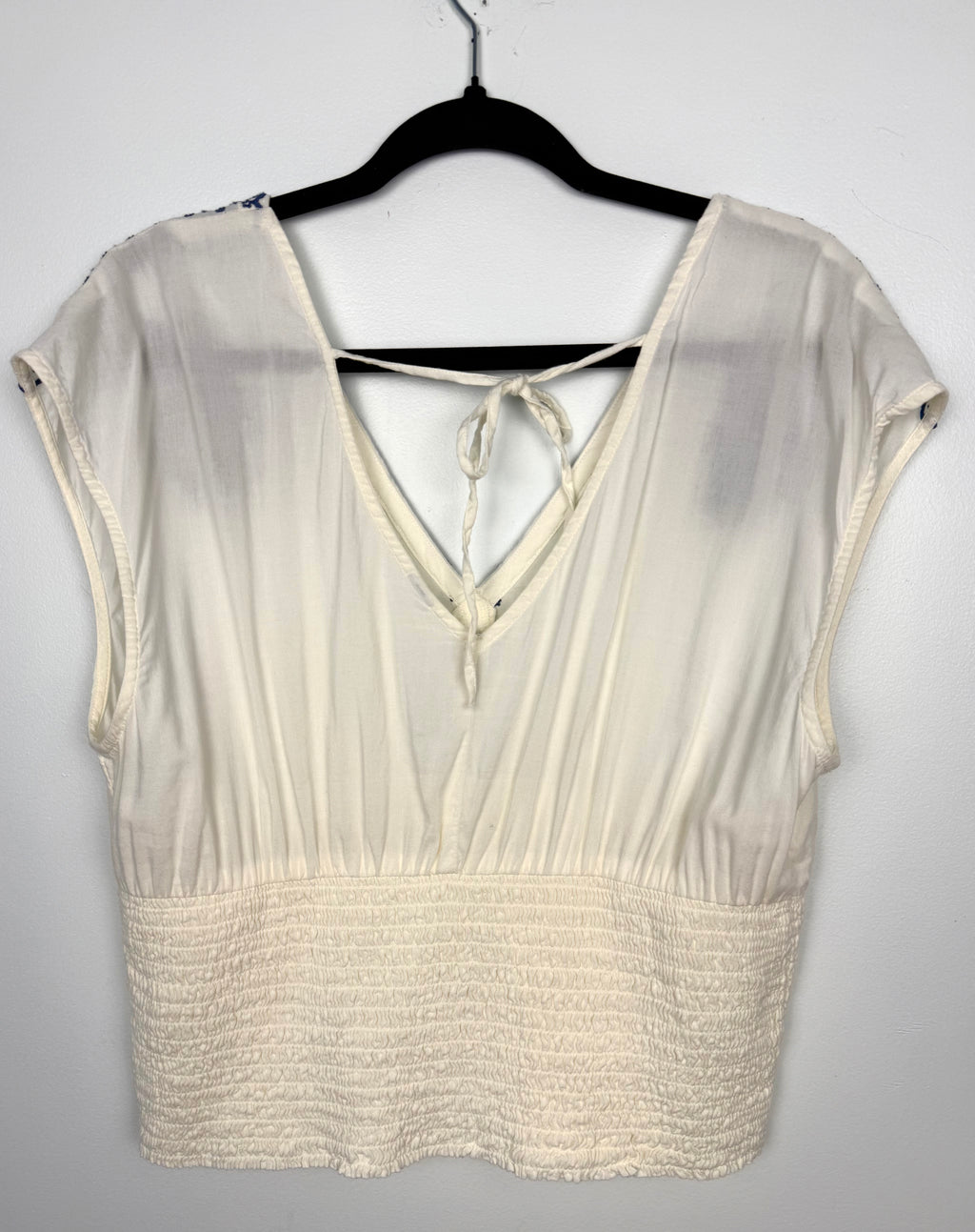 back of Boho Embroidered V-Neck Top Smocked Waist | Size L  at Blue Sparrow Shop on hanger