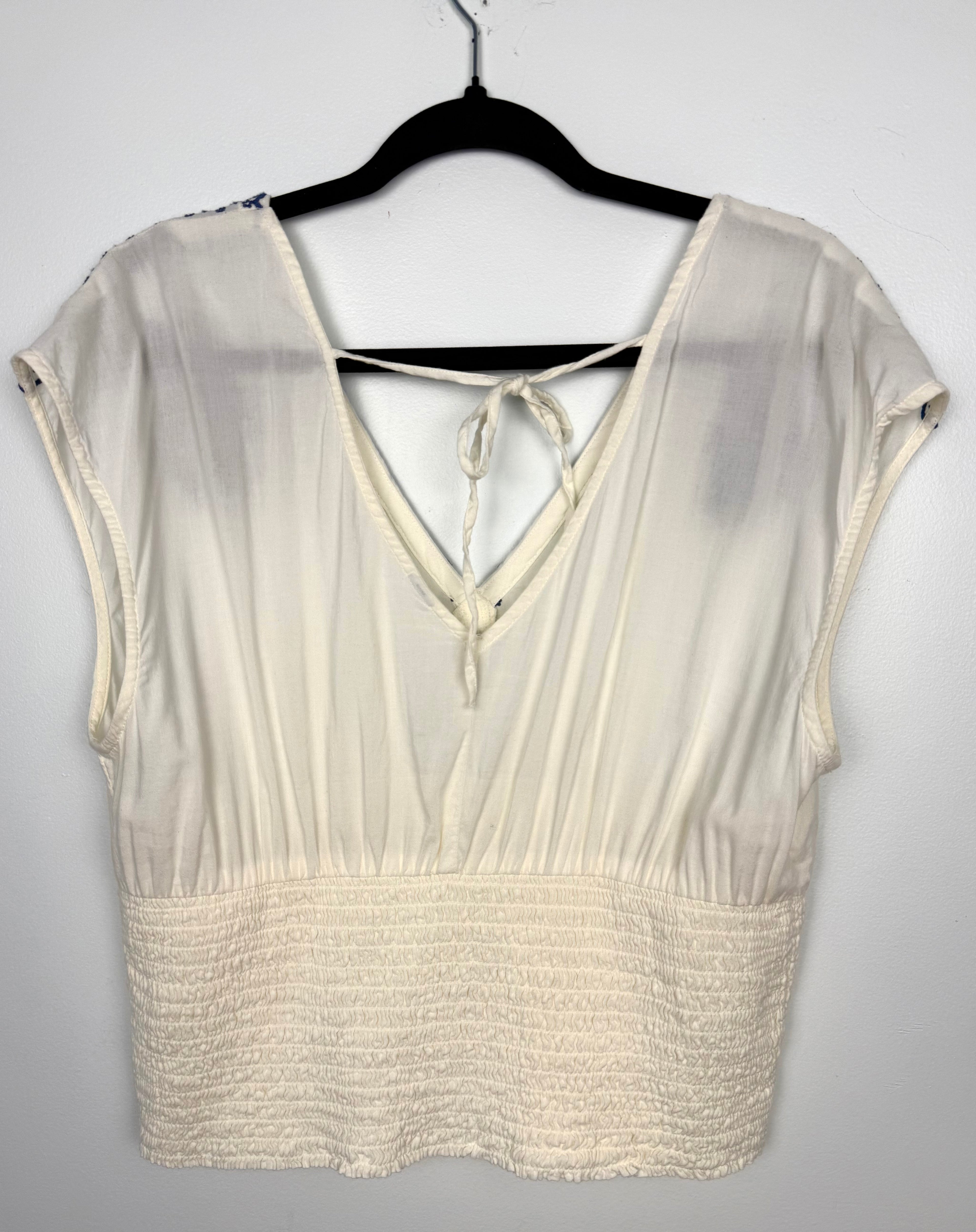 back of Boho Embroidered V-Neck Top Smocked Waist | Size L  at Blue Sparrow Shop on hanger