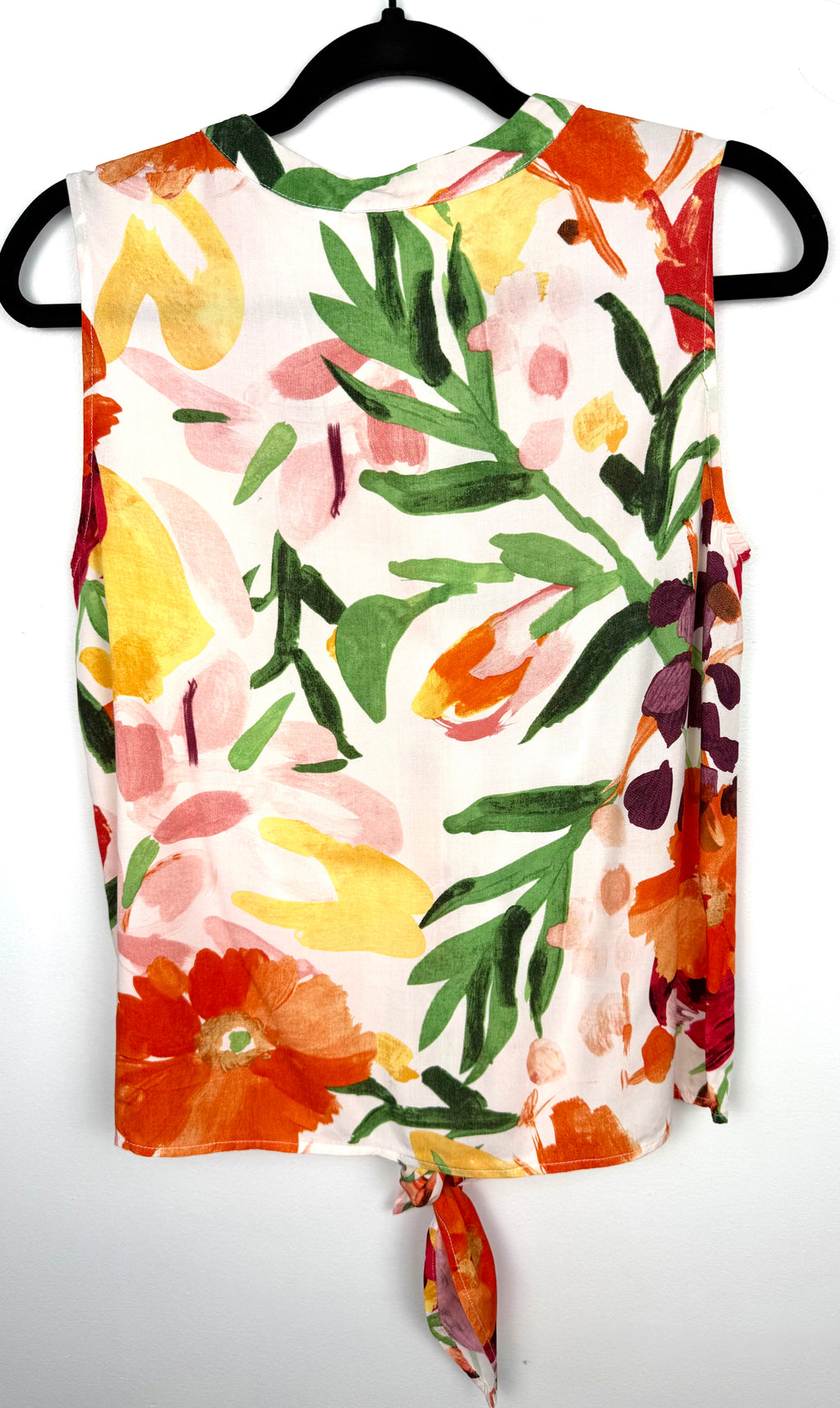 back of Cleo tie-front V-neck floral blouse in bold painterly orange red and green botanical print on hanger
