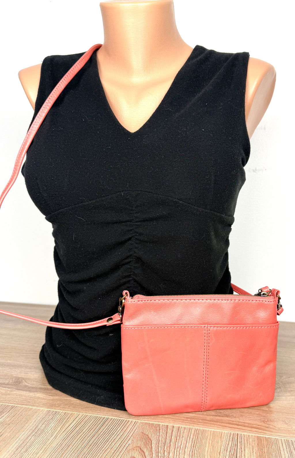 back of Coral Coloured HOBO International Leather Crossbody Wristlet Bag  on mannequin to show size