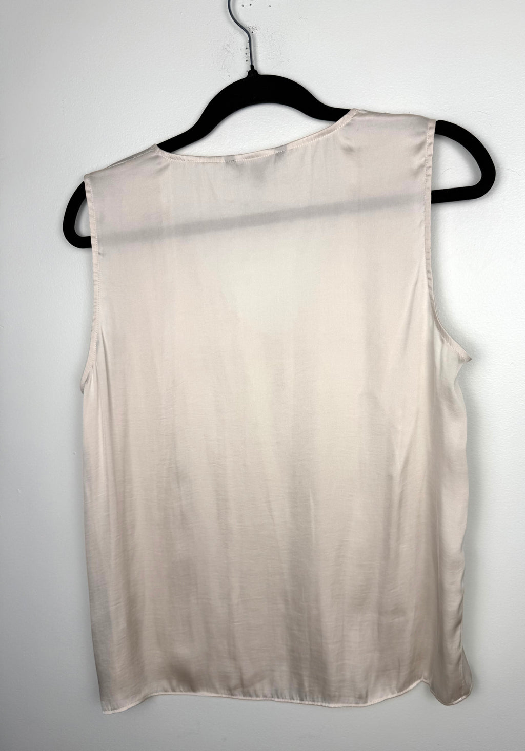 back of Cream Banana Republic sleeveless blouse featuring a V-neckline, gathered shoulder detail, relaxed silhouette, and fluid drape throughout the body on hanger