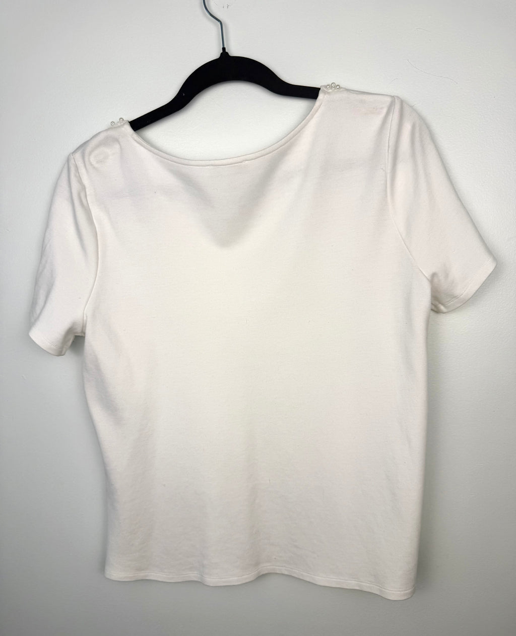 back of Laura Petites  Pearl Neckline Top on hanger