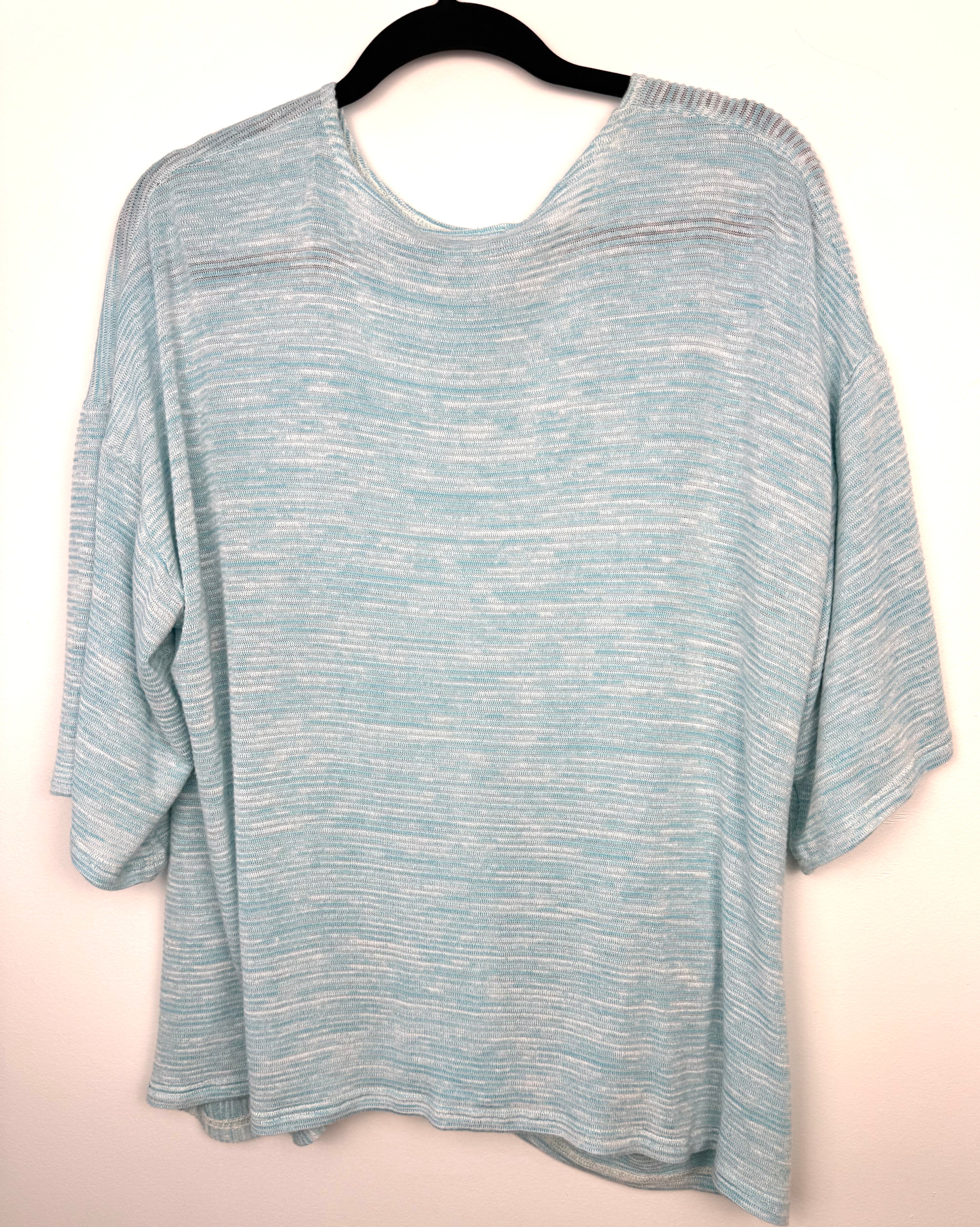 back of Pale Blue Sympli Knit Tunic Top with front pocket detail  on hanger
