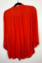 back of Rachel Zoe Vibrant Orange boho blouse on hanger