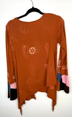 back of Tye dye boho artsy unique asymmetrical top in burnt orange   on hanger