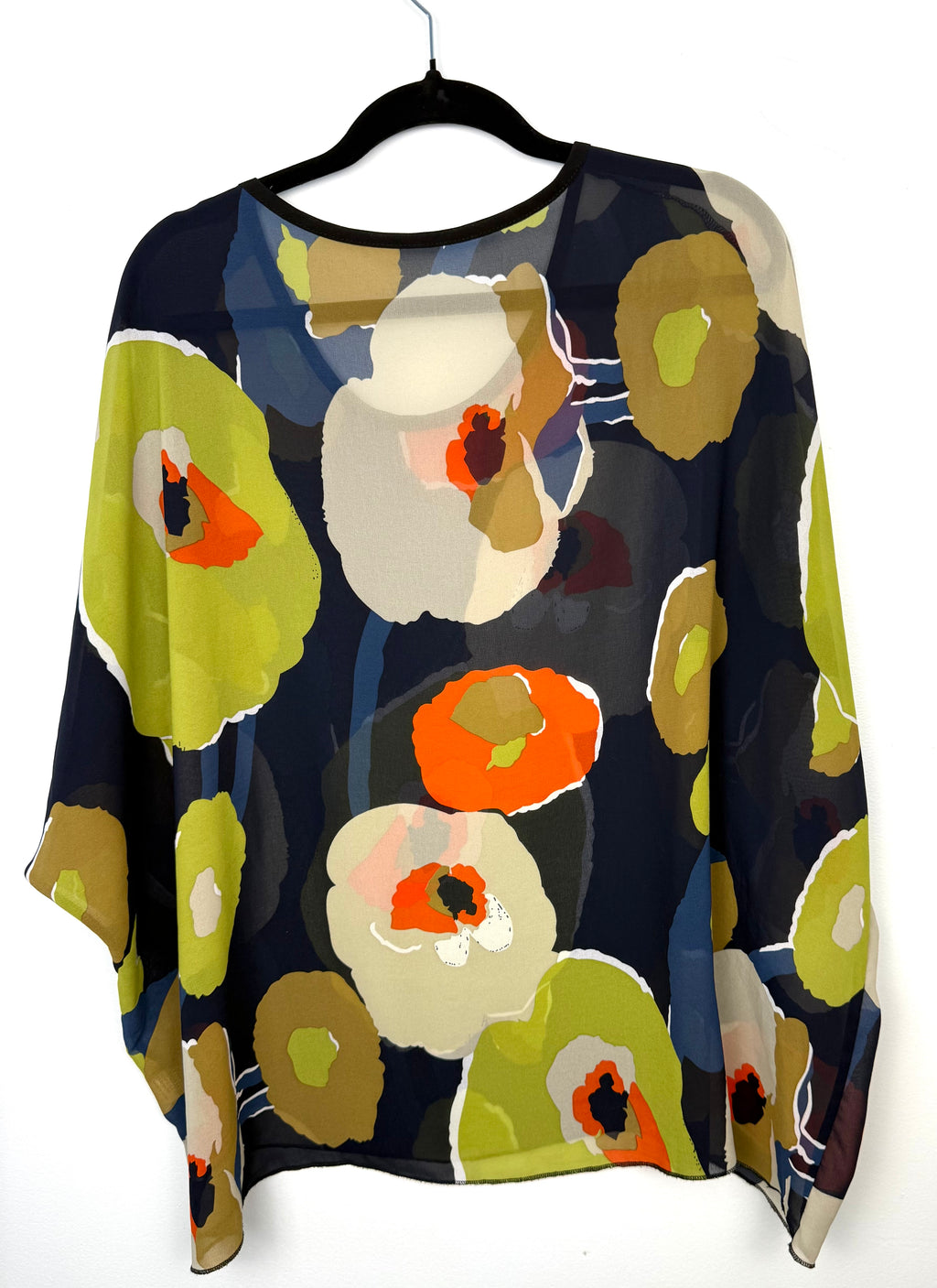back of oversized women’s blouse with bold abstract floral pattern  on hanger
