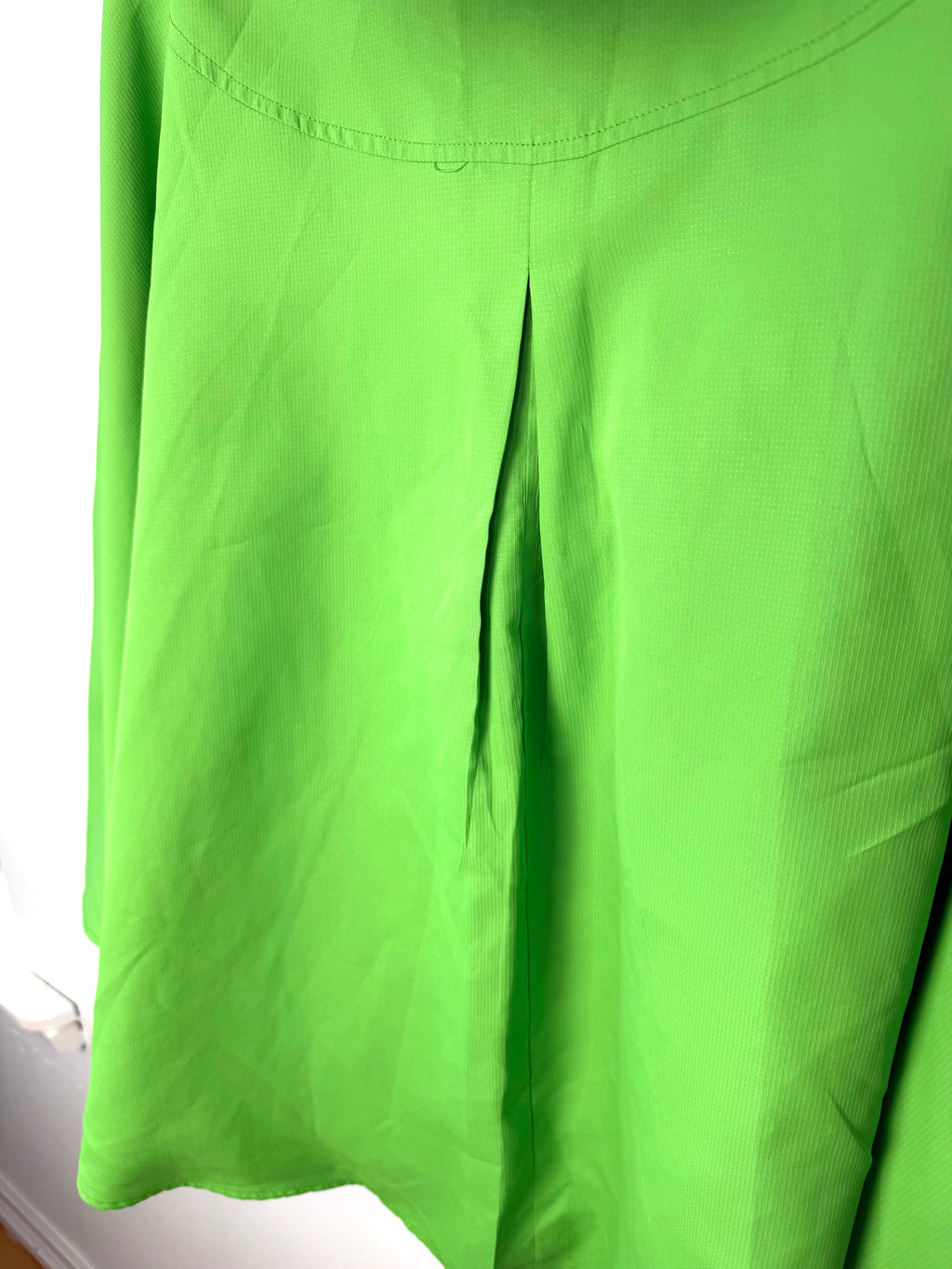 back pleat detail on women’s statement raincoat bold neon green outerwear 